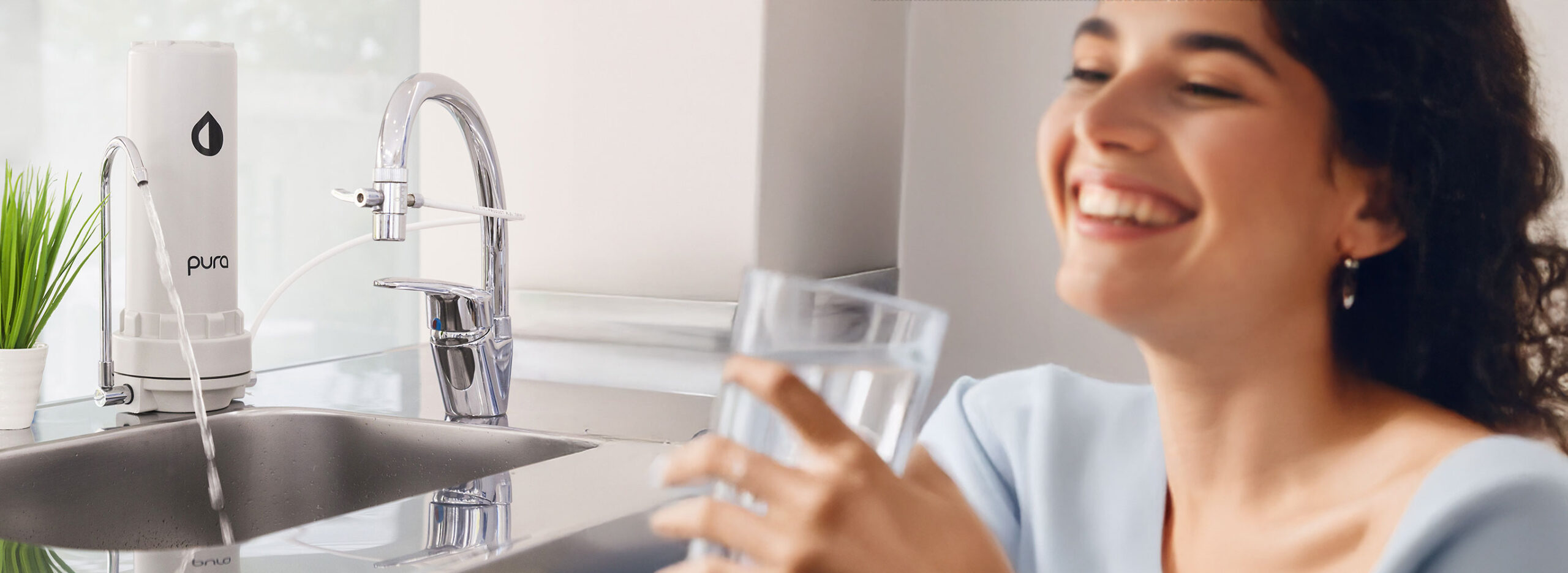 Mujer sonriendo con vaso de agua PURA en la mano, Compra Internacional PURA Argentina